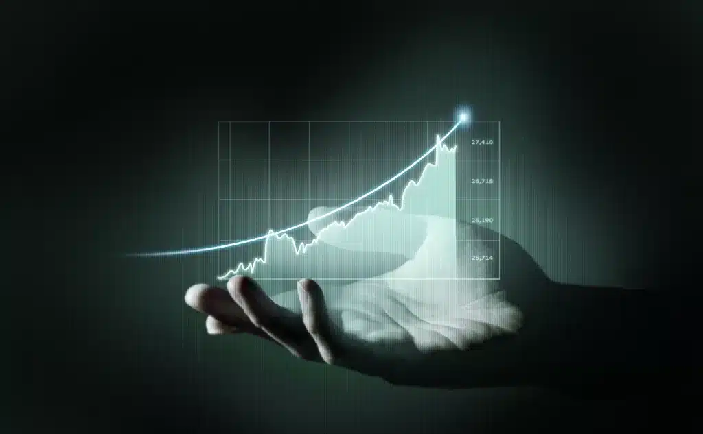 Uma mão aberta sustentando um holograma brilhante de um gráfico financeiro em ascensão pela automação de processos financeiros.