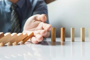 businessman hand stop dominoes continuous toppled or risk with copyspace